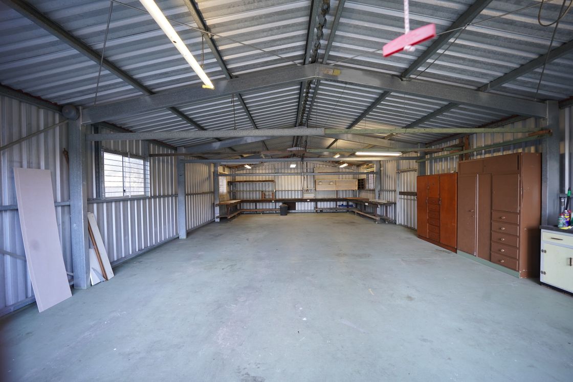 Interior of a steel-framed pole barn workshop with storage benches